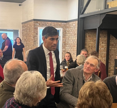 Rishi talking to attendees at the dinner